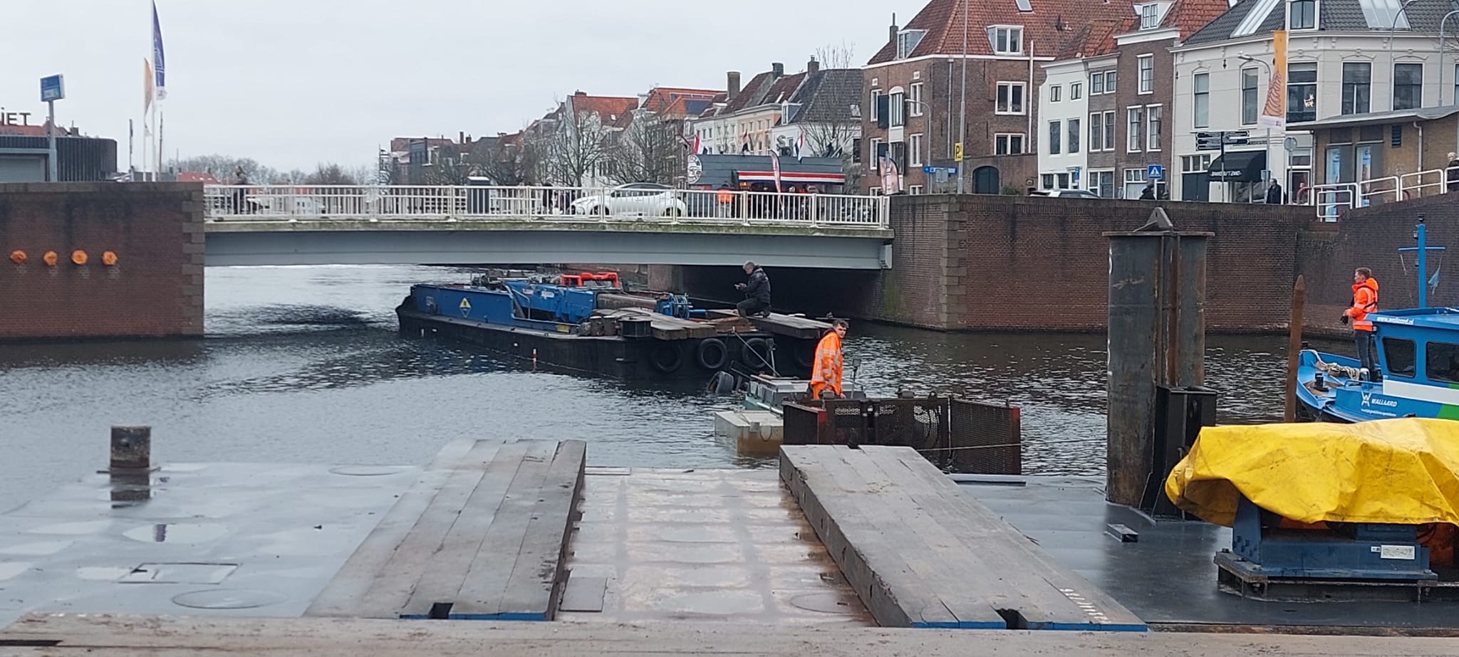 Duwbak die onder een lage brug in Middelharnis wordt begeleid